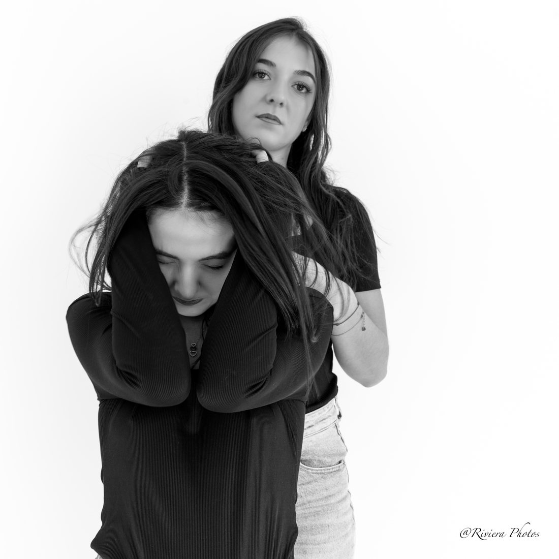 Portrait en noir et blanc de deux jeunes femmes, l'une cache son visage, l'autre regarde l'objectif